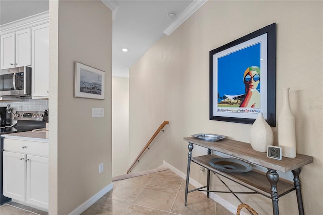 hallway with ornamental molding and light tile patterned floors