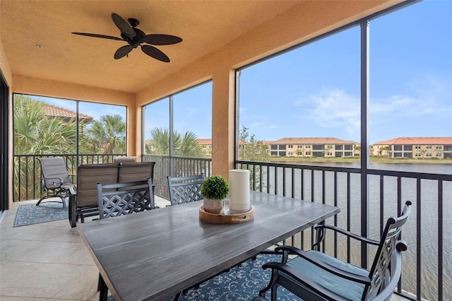 sunroom / solarium with a water view and ceiling fan