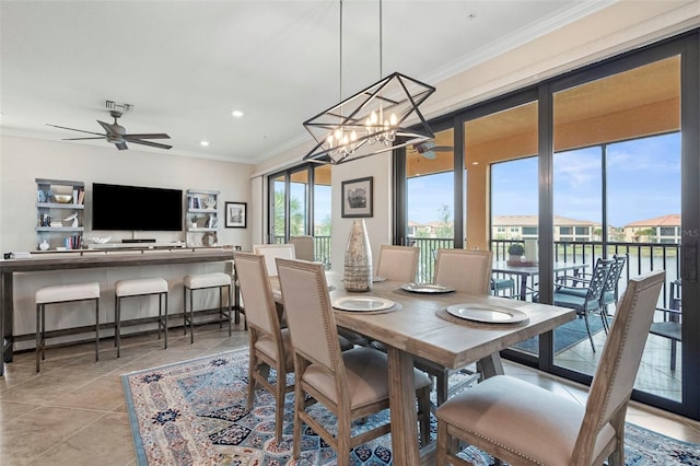 tiled dining room with ceiling fan, a healthy amount of sunlight, and ornamental molding