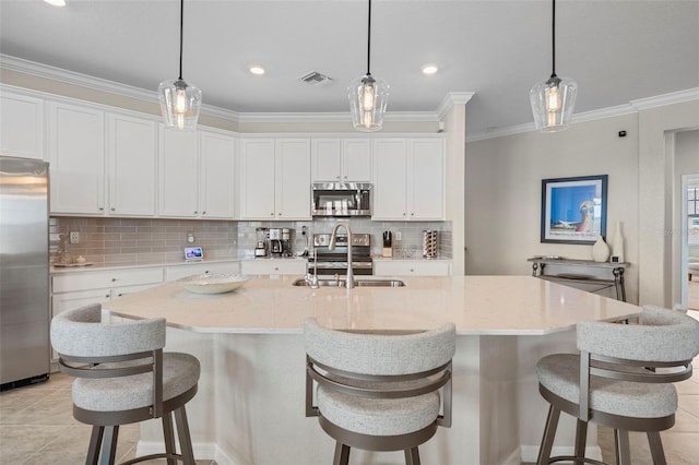 kitchen with a kitchen island with sink, sink, pendant lighting, and appliances with stainless steel finishes