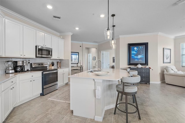 kitchen featuring white cabinetry, appliances with stainless steel finishes, sink, and a kitchen island with sink