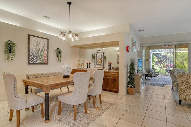 dining space with an inviting chandelier and light tile patterned floors