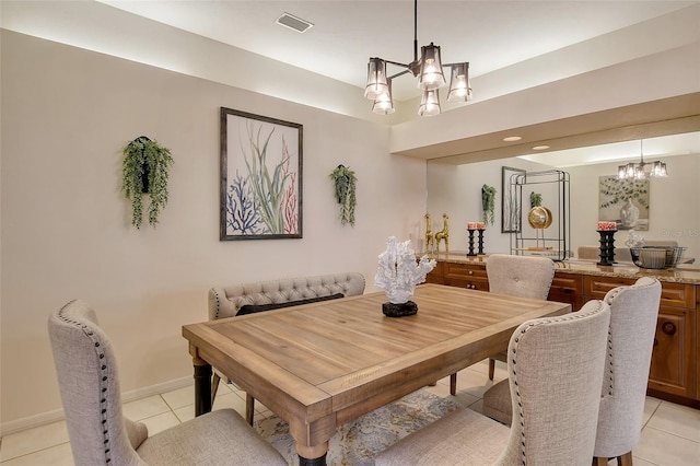 dining space with light tile patterned floors and an inviting chandelier