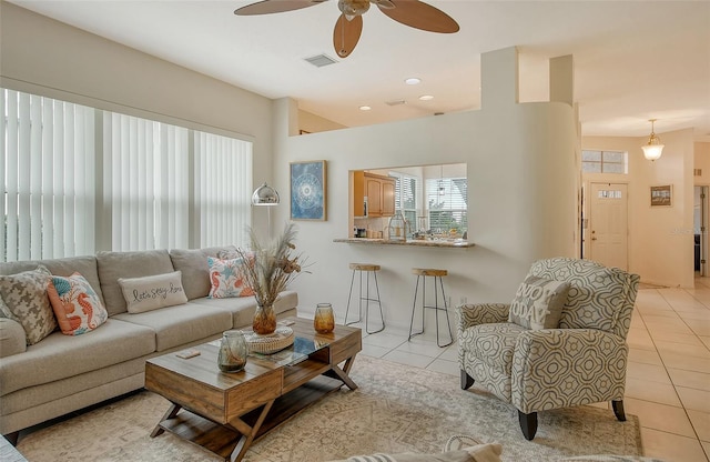 living room featuring light tile patterned floors and ceiling fan