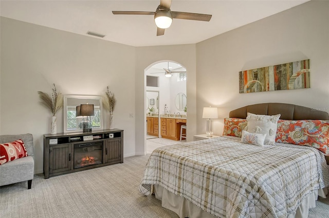 carpeted bedroom featuring ensuite bathroom and ceiling fan