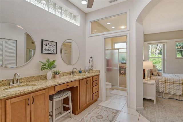 bathroom with tile patterned flooring, vanity, toilet, and walk in shower