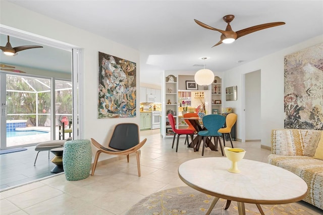 sitting room with ceiling fan, light tile patterned floors, and built in shelves