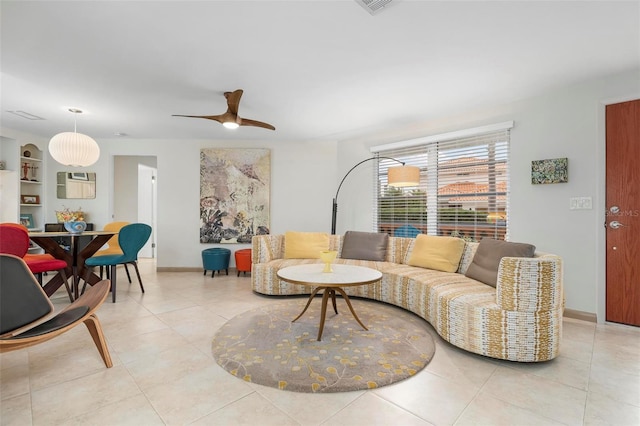 living room with ceiling fan, built in shelves, and light tile patterned floors