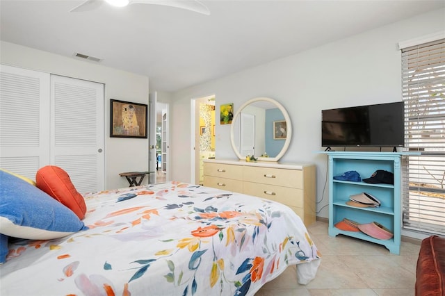 bedroom with ceiling fan, light tile patterned flooring, a closet, and multiple windows