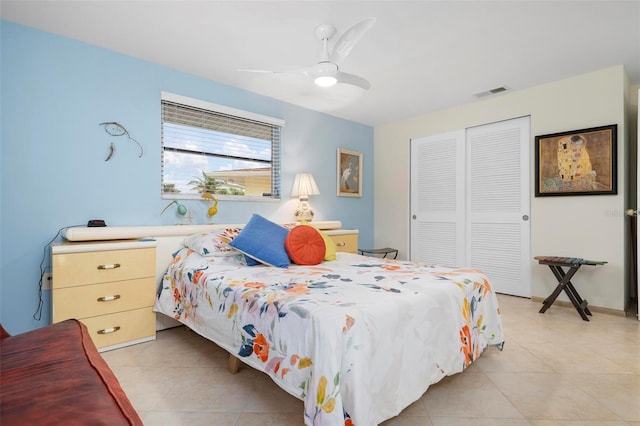 bedroom with ceiling fan, light tile patterned floors, and a closet