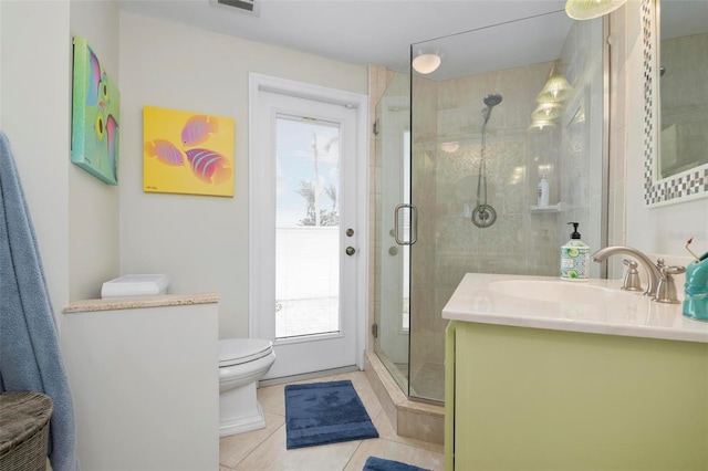 bathroom with tile patterned floors, a shower with door, toilet, and vanity