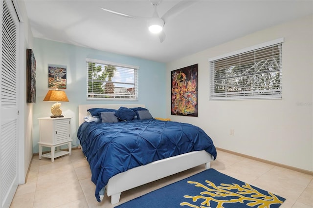 bedroom featuring ceiling fan, tile patterned floors, and a closet