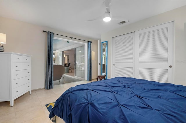 tiled bedroom with ceiling fan and a closet