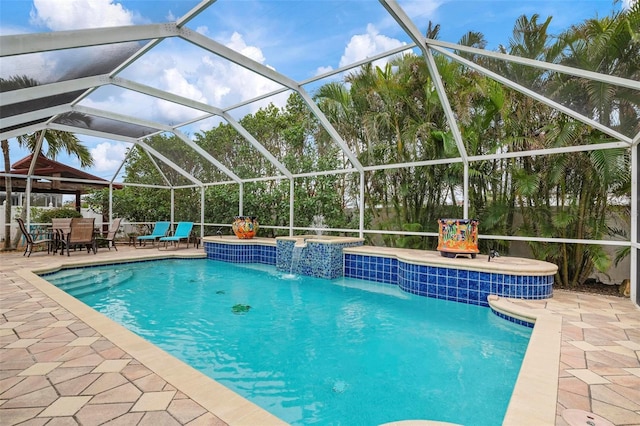 view of pool with a lanai, pool water feature, and a patio area