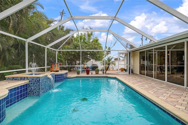 view of pool with pool water feature, glass enclosure, an in ground hot tub, and a patio