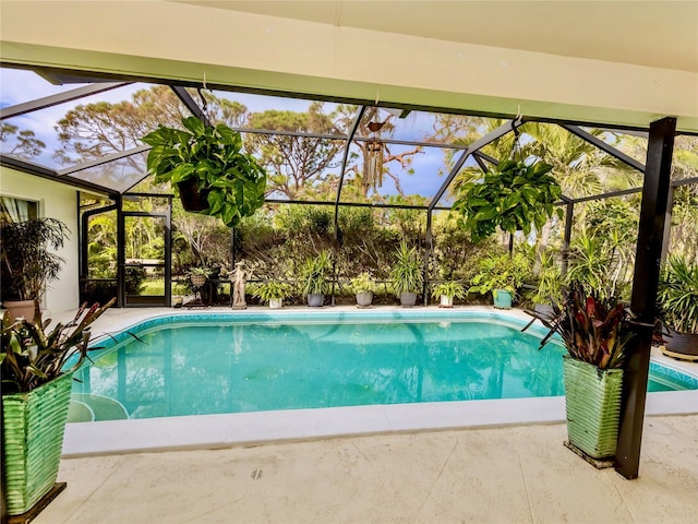 view of pool featuring glass enclosure and a patio