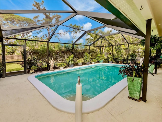 view of swimming pool with glass enclosure and a patio area