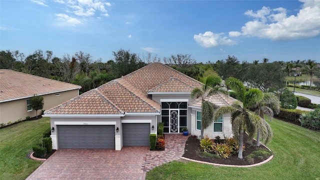 mediterranean / spanish-style house featuring a garage and a front lawn