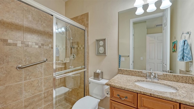 bathroom with vanity, a shower with door, and toilet