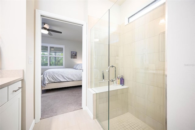 bathroom featuring ceiling fan, vanity, a shower with shower door, and a wealth of natural light