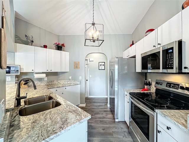 kitchen with sink, white cabinetry, hanging light fixtures, appliances with stainless steel finishes, and dark hardwood / wood-style flooring