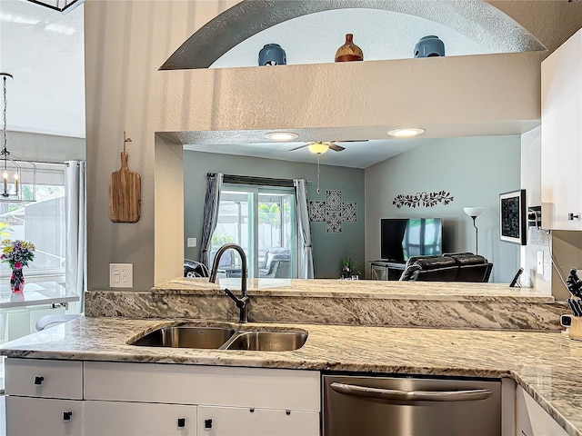 kitchen with white cabinetry, dishwasher, sink, ceiling fan, and light stone counters