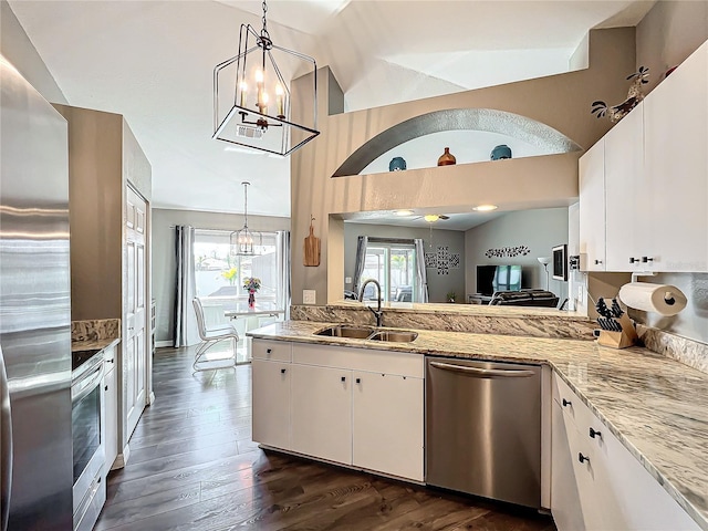 kitchen featuring hanging light fixtures, appliances with stainless steel finishes, sink, and white cabinets