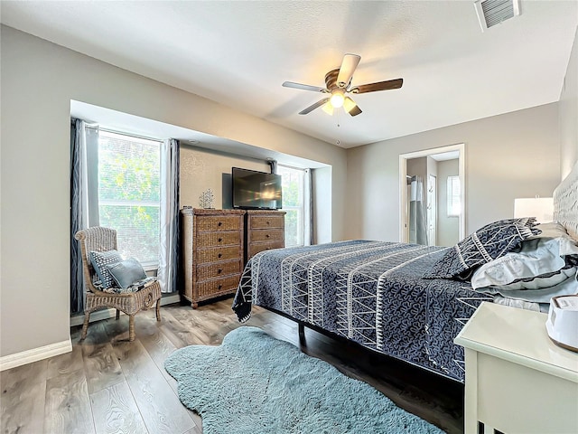 bedroom featuring wood-type flooring, connected bathroom, and ceiling fan