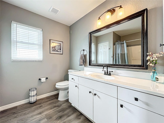 bathroom featuring a shower with curtain, vanity, wood-type flooring, and toilet