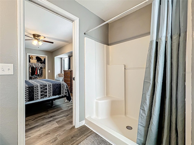 bathroom with curtained shower, ceiling fan, and hardwood / wood-style flooring