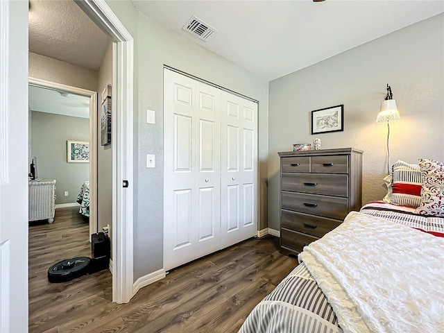 bedroom featuring dark hardwood / wood-style floors and a closet