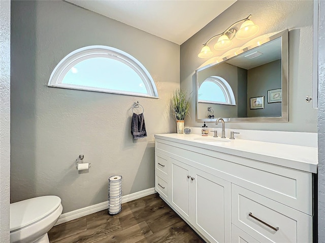 bathroom with hardwood / wood-style flooring, vanity, and toilet