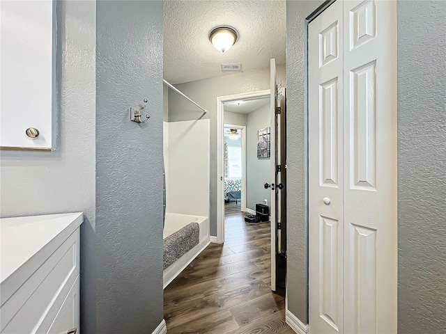 bathroom featuring hardwood / wood-style flooring, vanity, and a textured ceiling