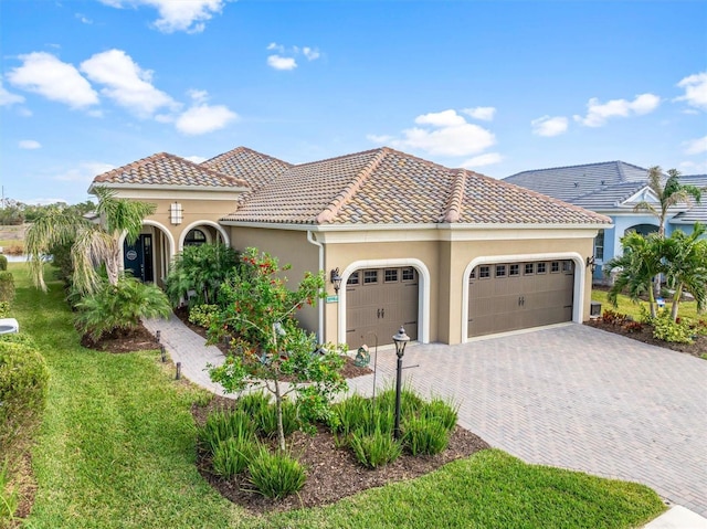 mediterranean / spanish house with a garage and a front yard