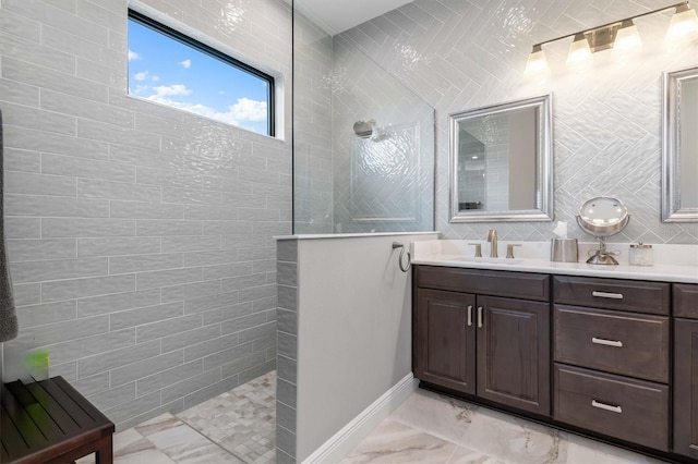 bathroom featuring tile walls, tiled shower, and vanity