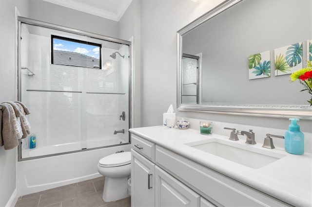 full bathroom featuring shower / bath combination with glass door, tile patterned floors, vanity, toilet, and crown molding