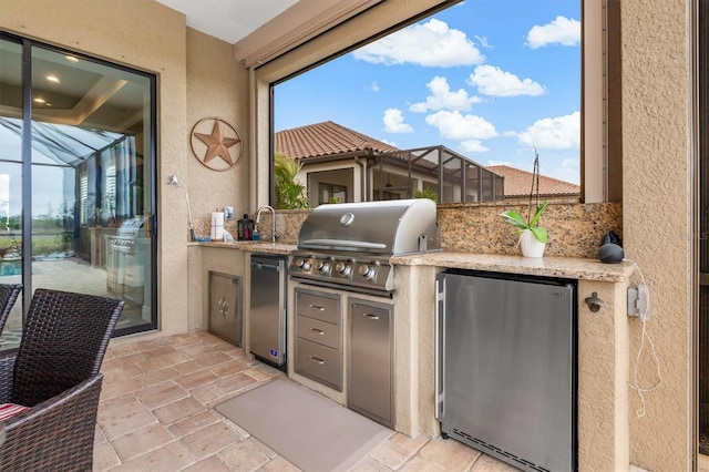 view of patio with an outdoor kitchen, a lanai, and a grill