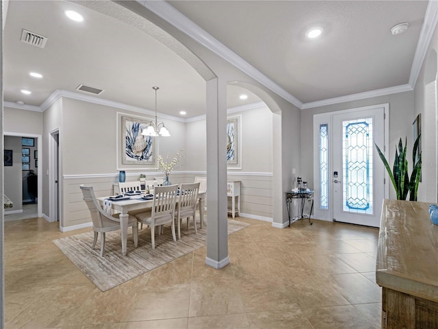 entryway with a chandelier and crown molding