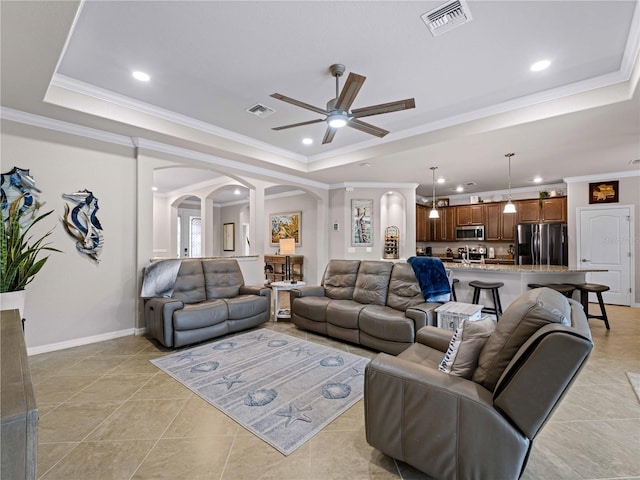 tiled living room featuring ornamental molding and a raised ceiling