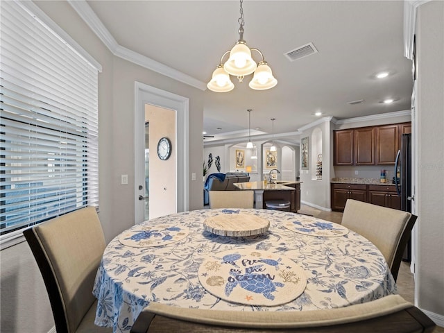 dining space featuring ornamental molding and a notable chandelier