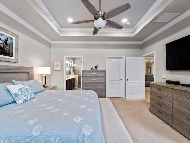 bedroom with ceiling fan, ensuite bathroom, a raised ceiling, and light carpet