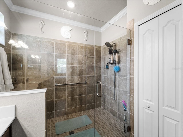 bathroom with a shower with shower door, vanity, and crown molding