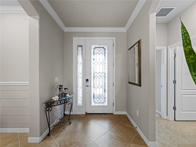 foyer entrance with light tile patterned floors and crown molding