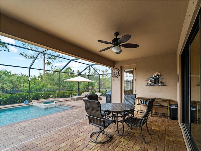 view of patio / terrace featuring glass enclosure and a pool with hot tub