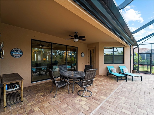 view of patio / terrace with ceiling fan and a lanai