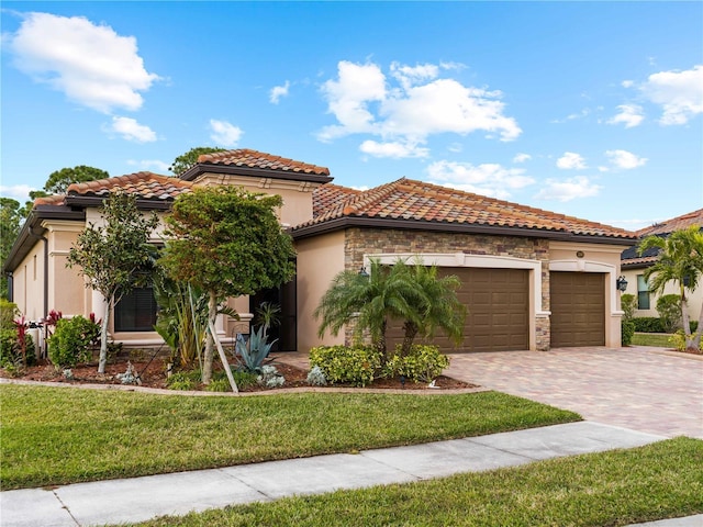 mediterranean / spanish home featuring a garage and a front yard