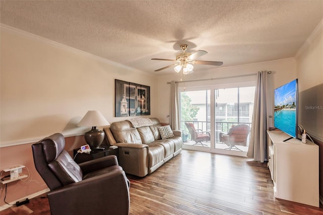 living room with ceiling fan, a textured ceiling, ornamental molding, and hardwood / wood-style floors