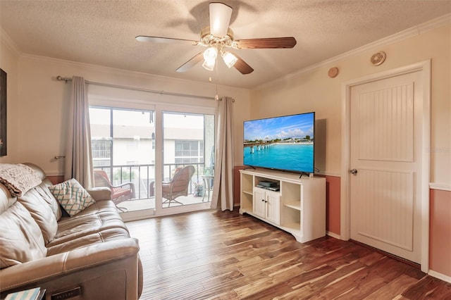 living room featuring ceiling fan, a textured ceiling, hardwood / wood-style flooring, and ornamental molding