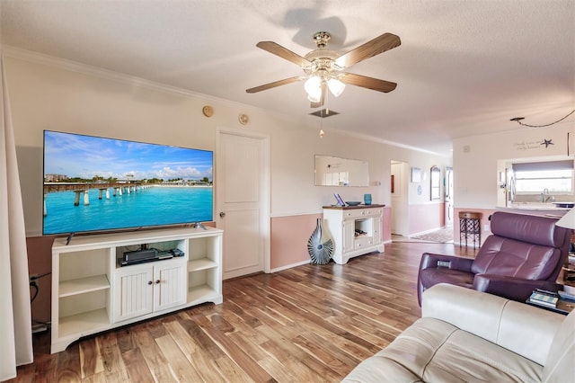 living room featuring ceiling fan, crown molding, and hardwood / wood-style floors