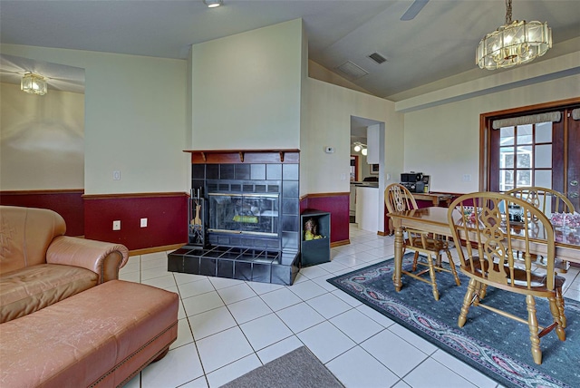 tiled dining room with a fireplace and lofted ceiling